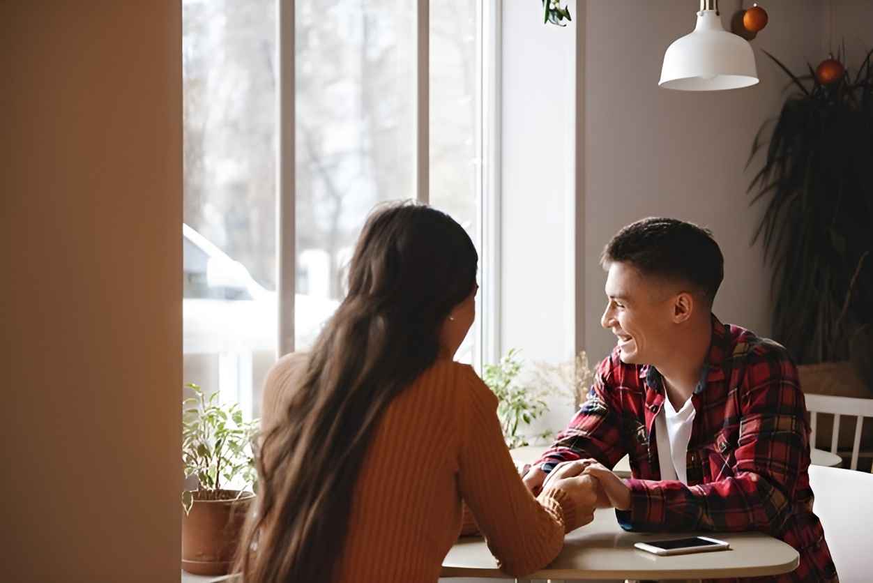 Portrait of a young couple holding hands in a cafe